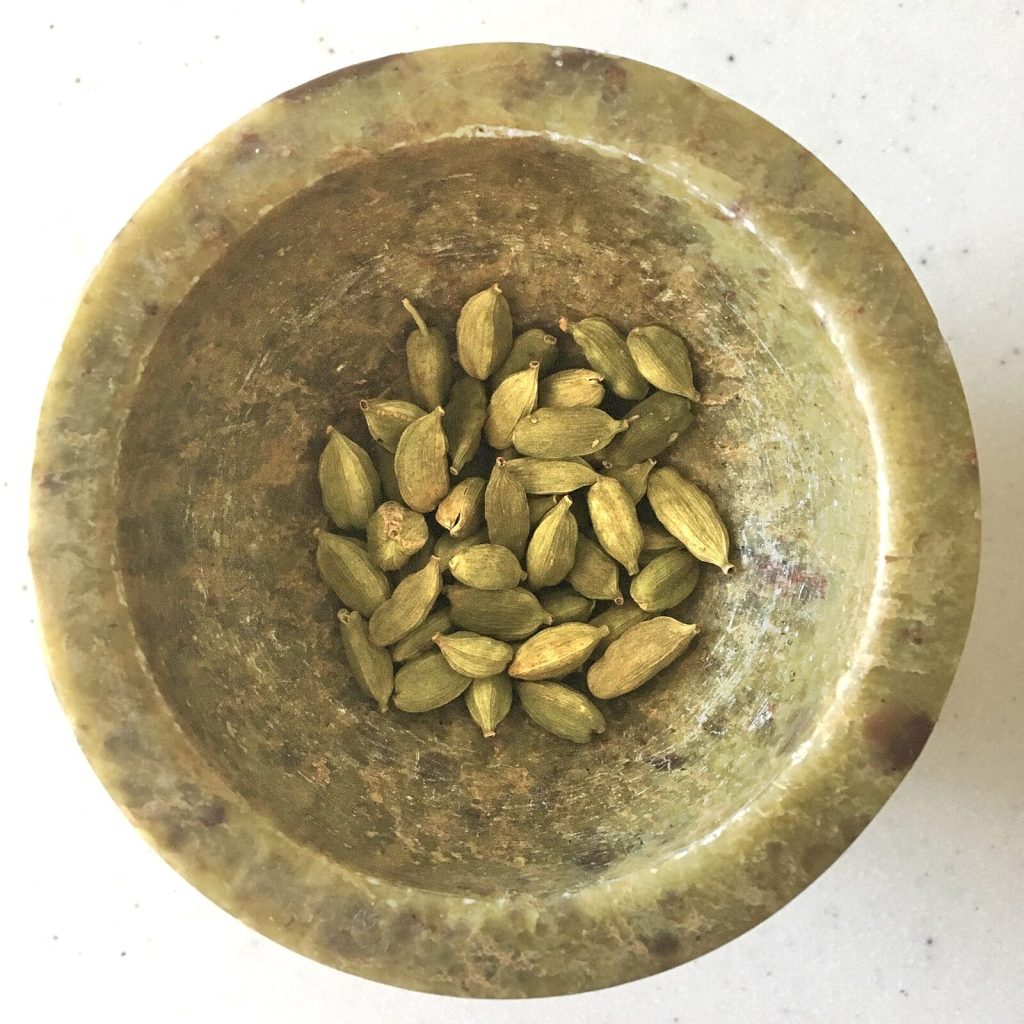 Green cardamom pods in a bowl